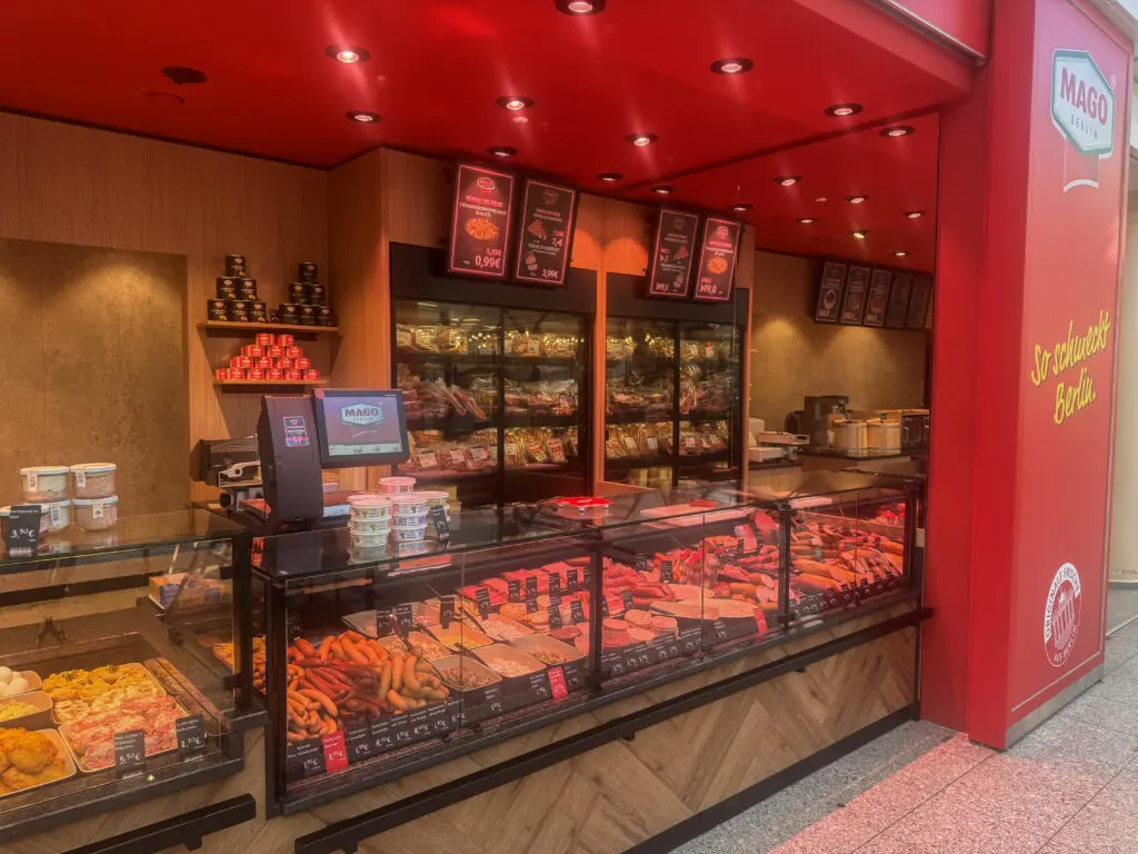 Fleischerei MAGO in Berlin mit roter Decke, Fleischtheke und Wurstwaren in der Auslage.