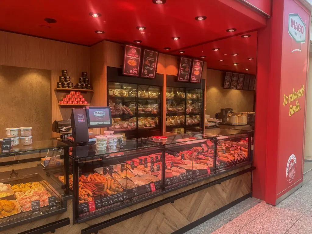 Fleischerei MAGO in Berlin mit roter Decke, Fleischtheke und Wurstwaren in der Auslage.