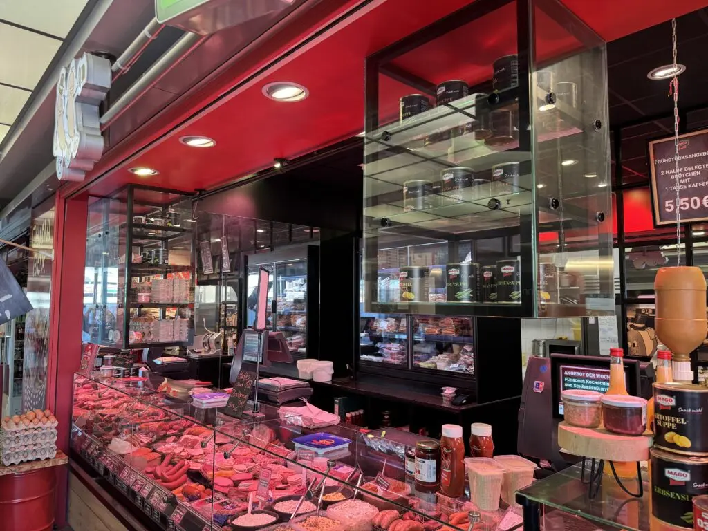 Fleischereitheke von MAGO im Märkischen Zentrum Berlin mit Glasregalen für Zusatzprodukte und Wurstwaren in der Auslage.