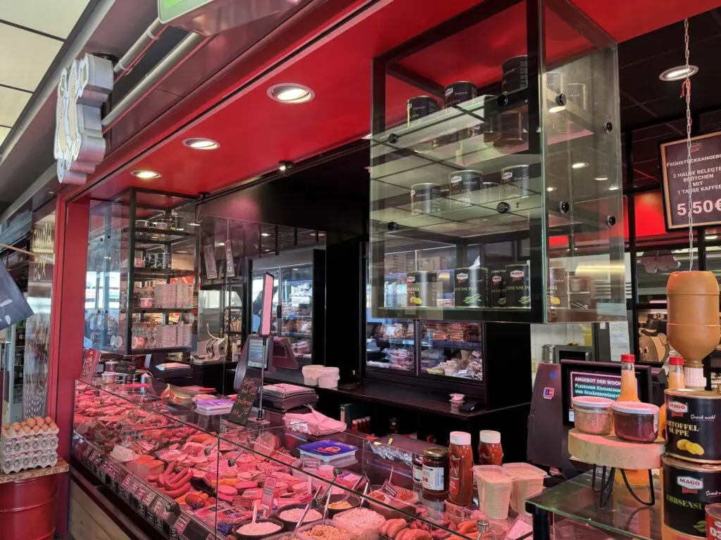 Fleischereitheke von MAGO im Märkischen Zentrum Berlin mit Glasregalen für Zusatzprodukte und Wurstwaren in der Auslage.