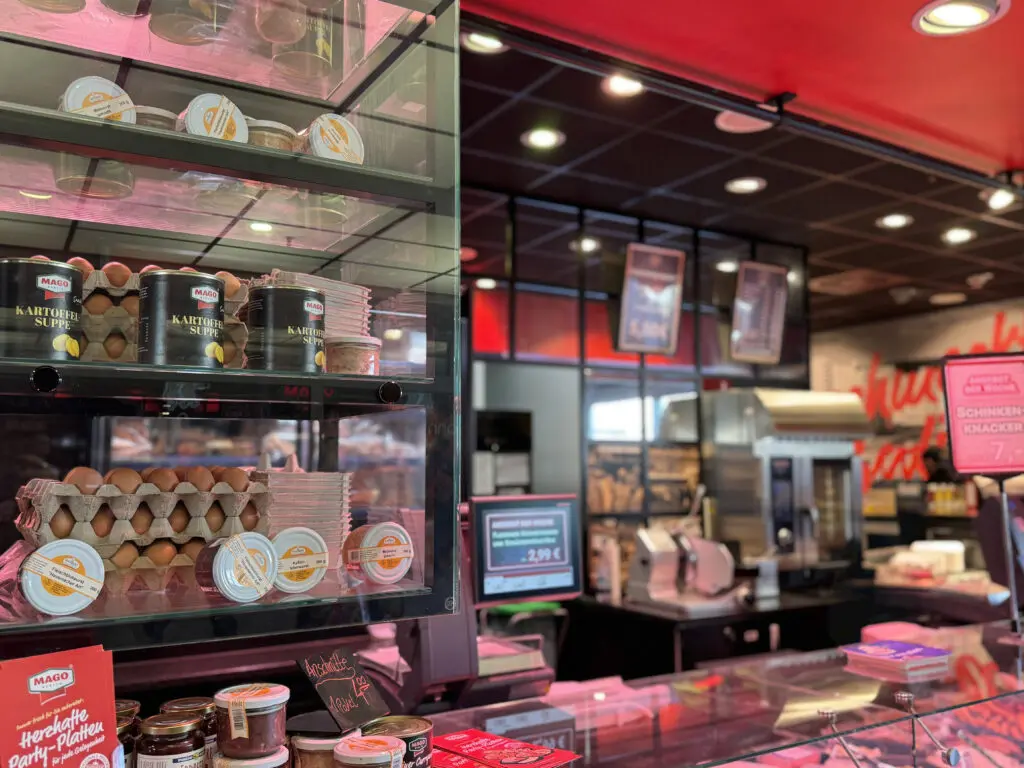 Glasregal bei MAGO im Märkischen Zentrum Berlin mit Zusatzprodukten über der Fleischtheke.