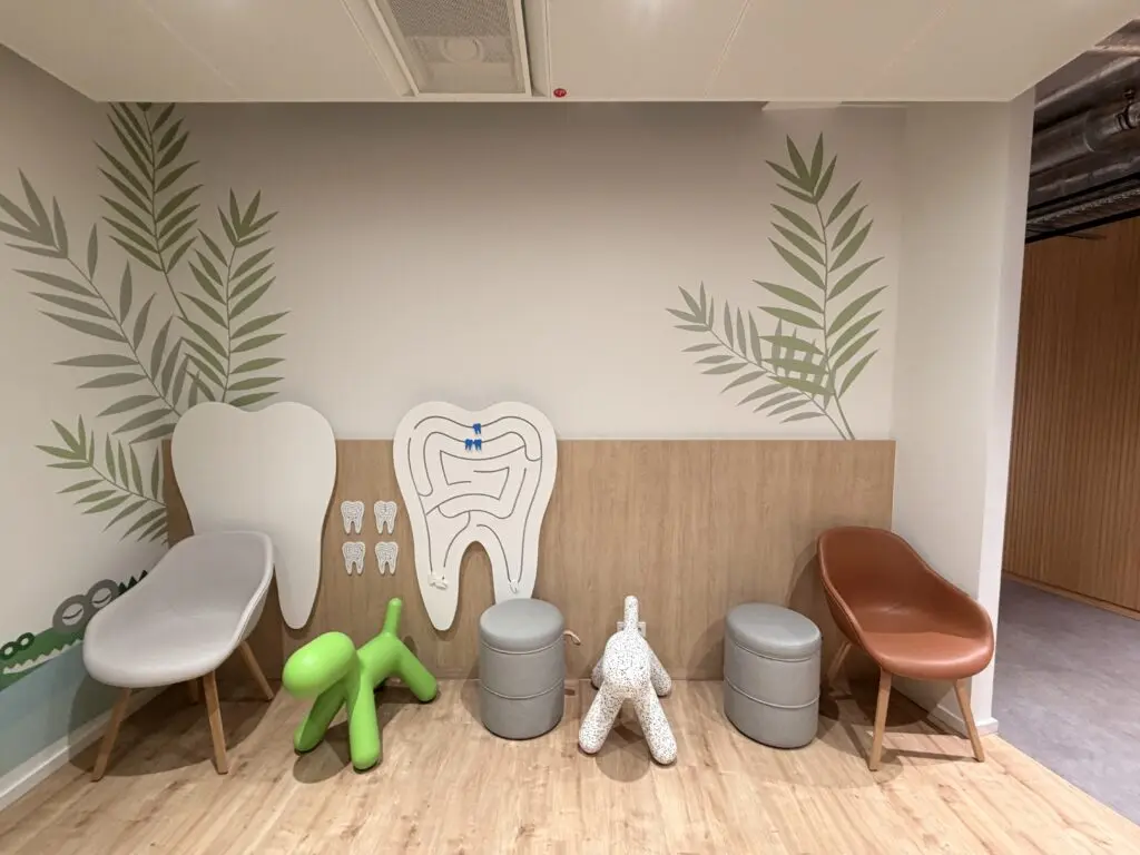 Kinderbereich im Zahnzentrum der AOK Düsseldorf Stadtmitte mit spielerischer Zahnvorsorge-Station, Sitzplätzen und kindgerechter Einrichtung.