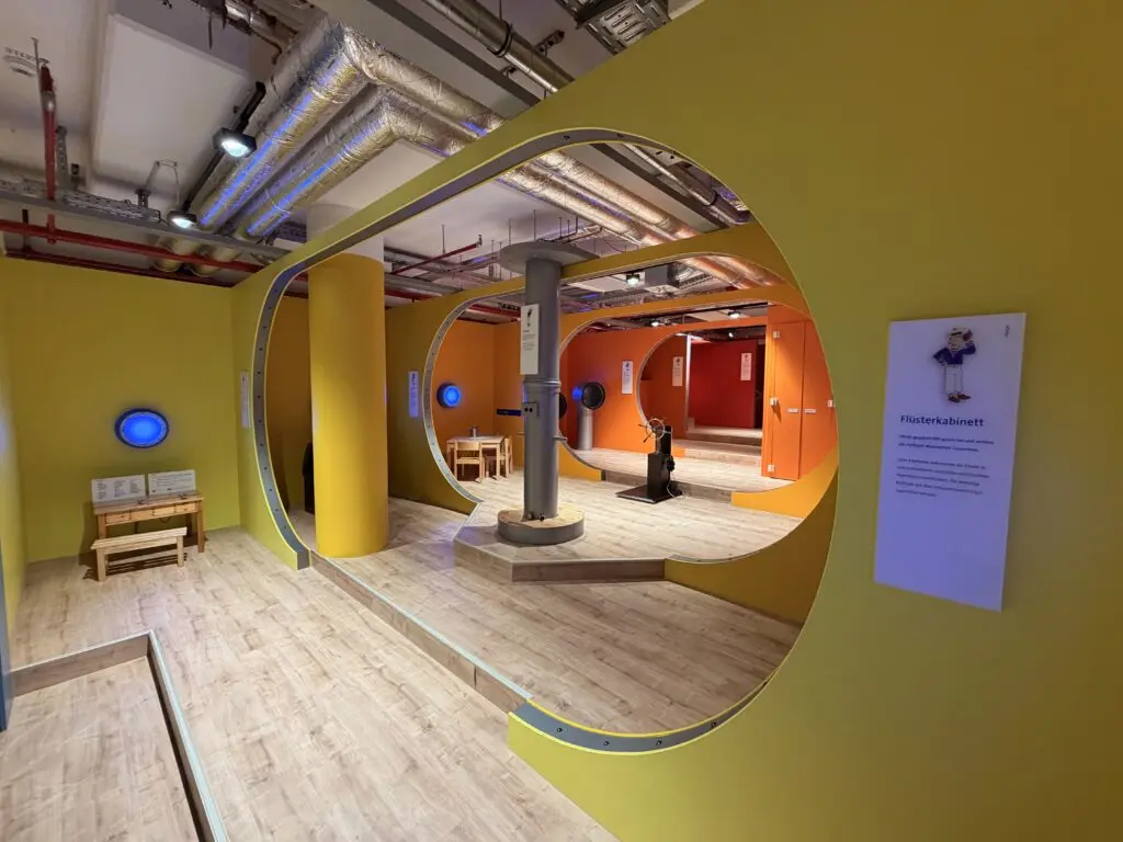 AOK U-Boot Gesundheitszentrum für Kinder mit Flüsterkabinett, runden U-Boot-Elementen und spielerischer Station zum Hören.