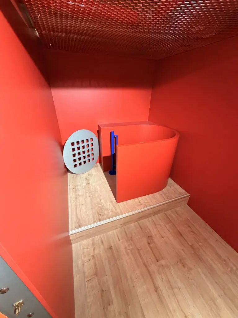 Rote Erlebnisstation im AOK U-Boot Gesundheitszentrum für Kinder mit spielerischer Raumgestaltung und Holzboden.