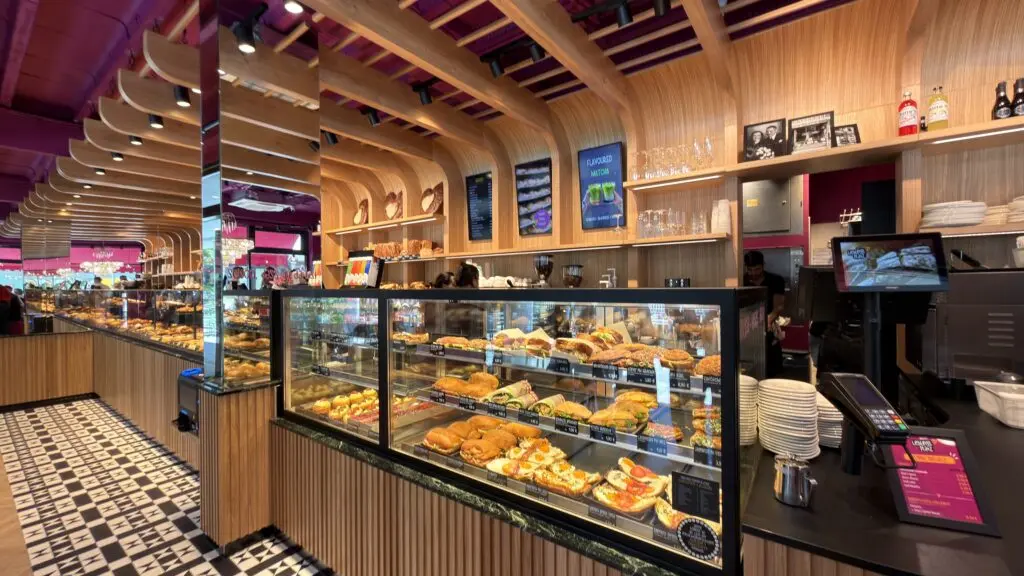 Kühlvitrine in der Bäckerei Huck in Frankfurt mit belegten Snacks, Gebäck und heller Bäckereieinrichtung.