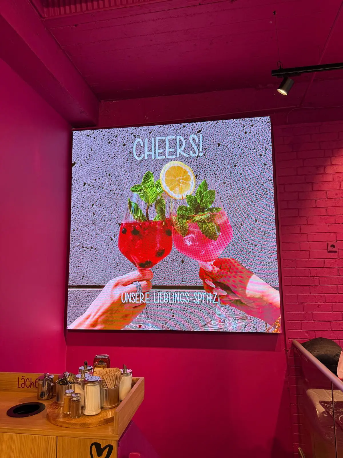 Große LED-Wand als Werbefläche in der Bäckerei Huck in Frankfurt mit Getränkemotiv im Cafébereich.