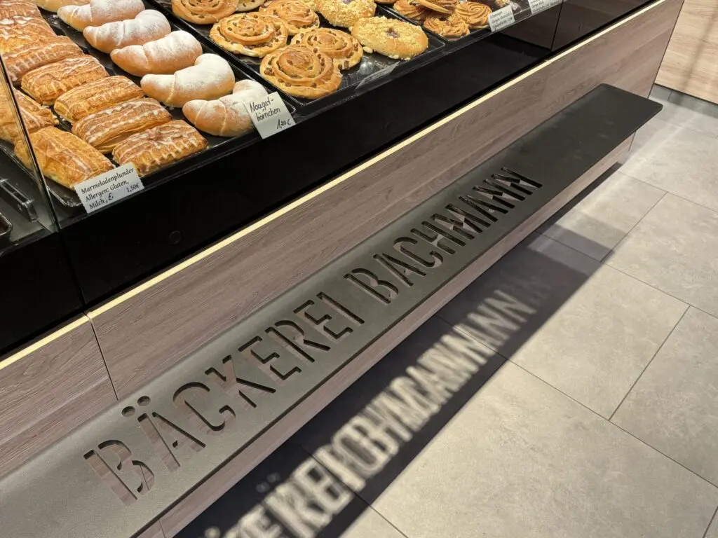 Taschenablage an der Verkaufstheke der Bäckerei Bachmann in Küllstedt mit Gebäck in der Auslage.